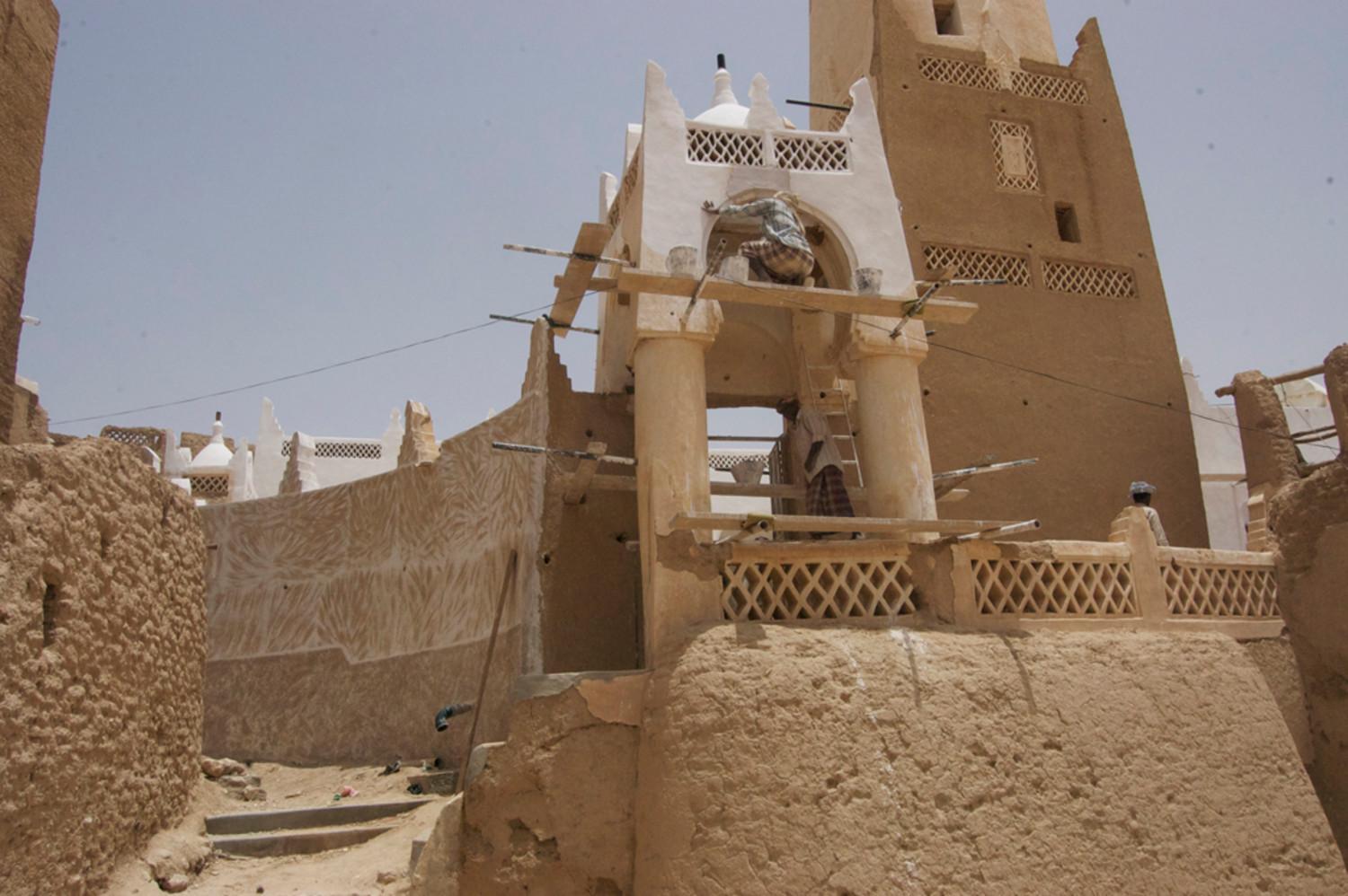 Eastern entrance and minaret base to the right, showing the extension of the south wall also being re-plastered in several coatings of mud followed by nurah