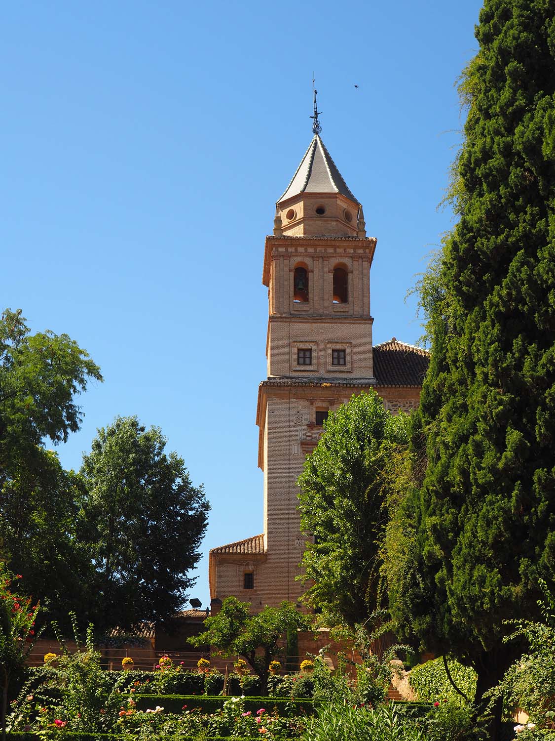 View of the bell tower of the Iglesia de Santa Maria de la Alhambra from the Jardines del Partal