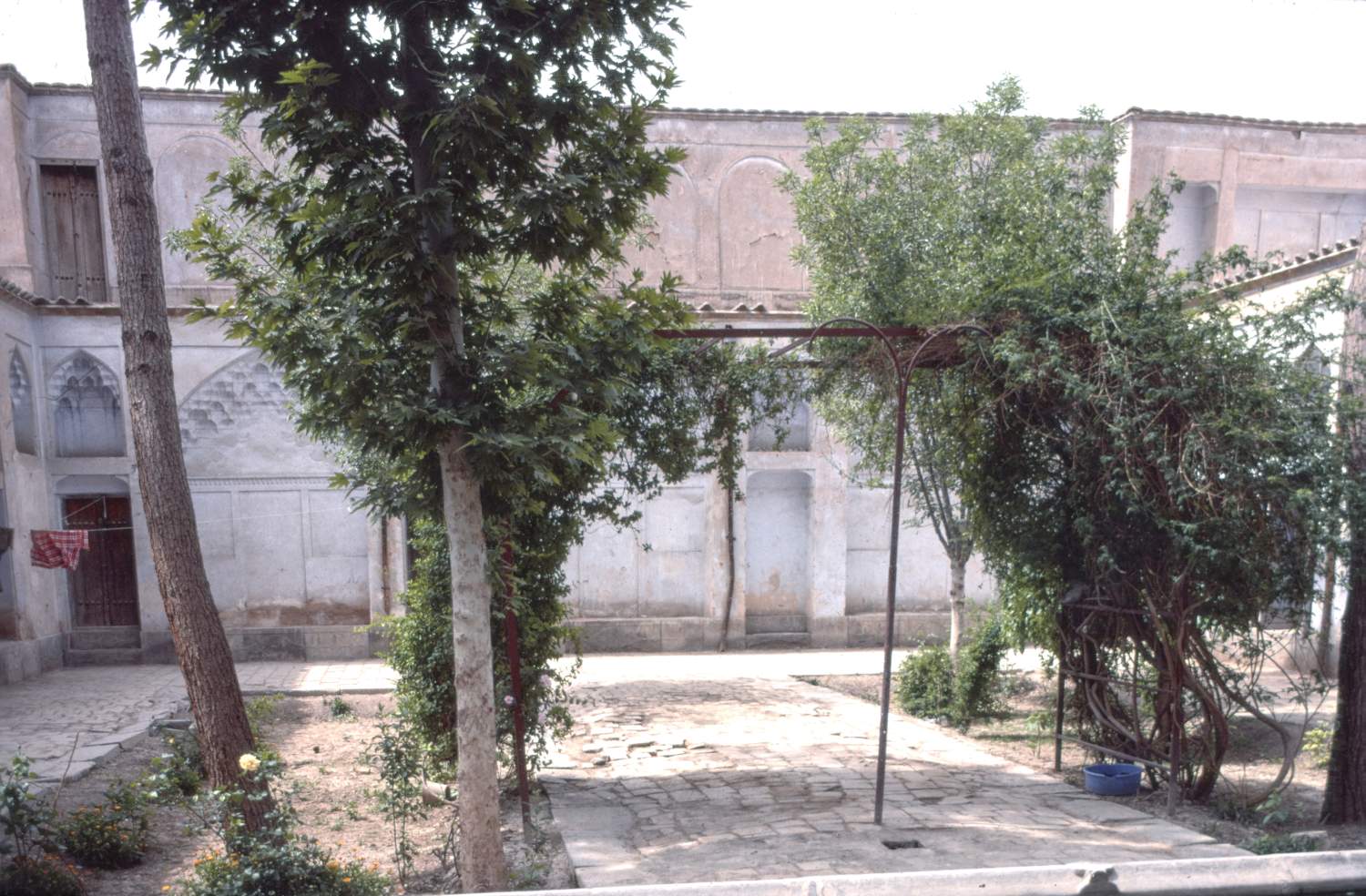 View of southern facade of courtyard from north side, looking down central axis between plant beds.