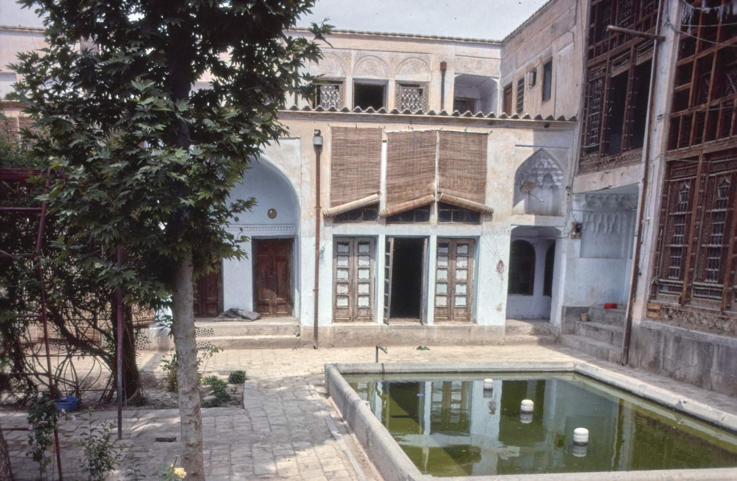 View of northwestern corner of courtyard from east side, showing rectangular pool below large windows.