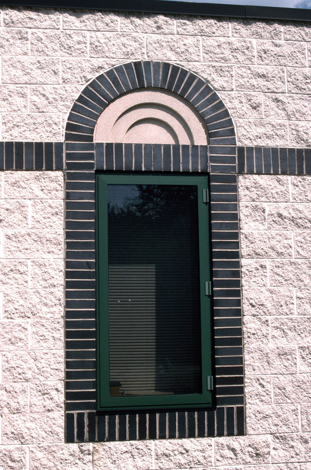 Exterior, detail of a window with colored-brick banding