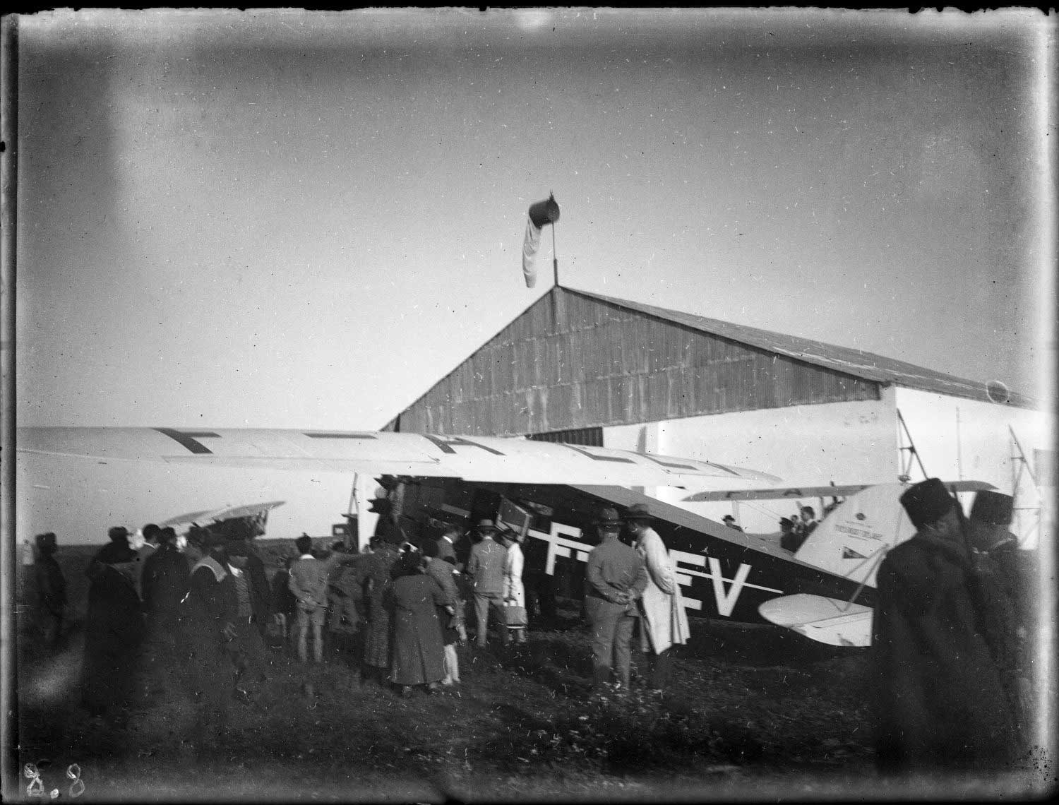 Aeroport Ibn Battouta de Tanger - A group of people in European and local clothing looking at an airplane near its hanger