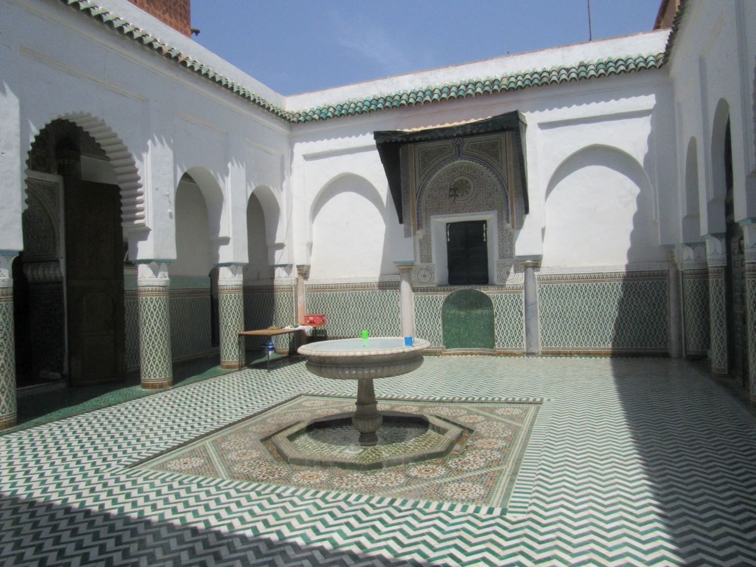 Courtyard view past the fountain toward the elaborately decorate tomb wall