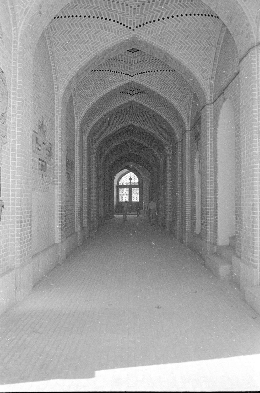 View along corridor leading from a side entrance toward the courtyard, facing the entrance end of the corridor.
