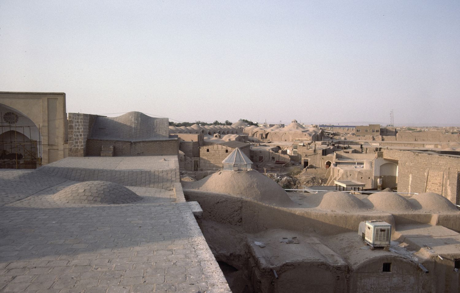 View from roof over the area surrounding the mosque. The domed roof of a covered bazaar street is visible in the background.