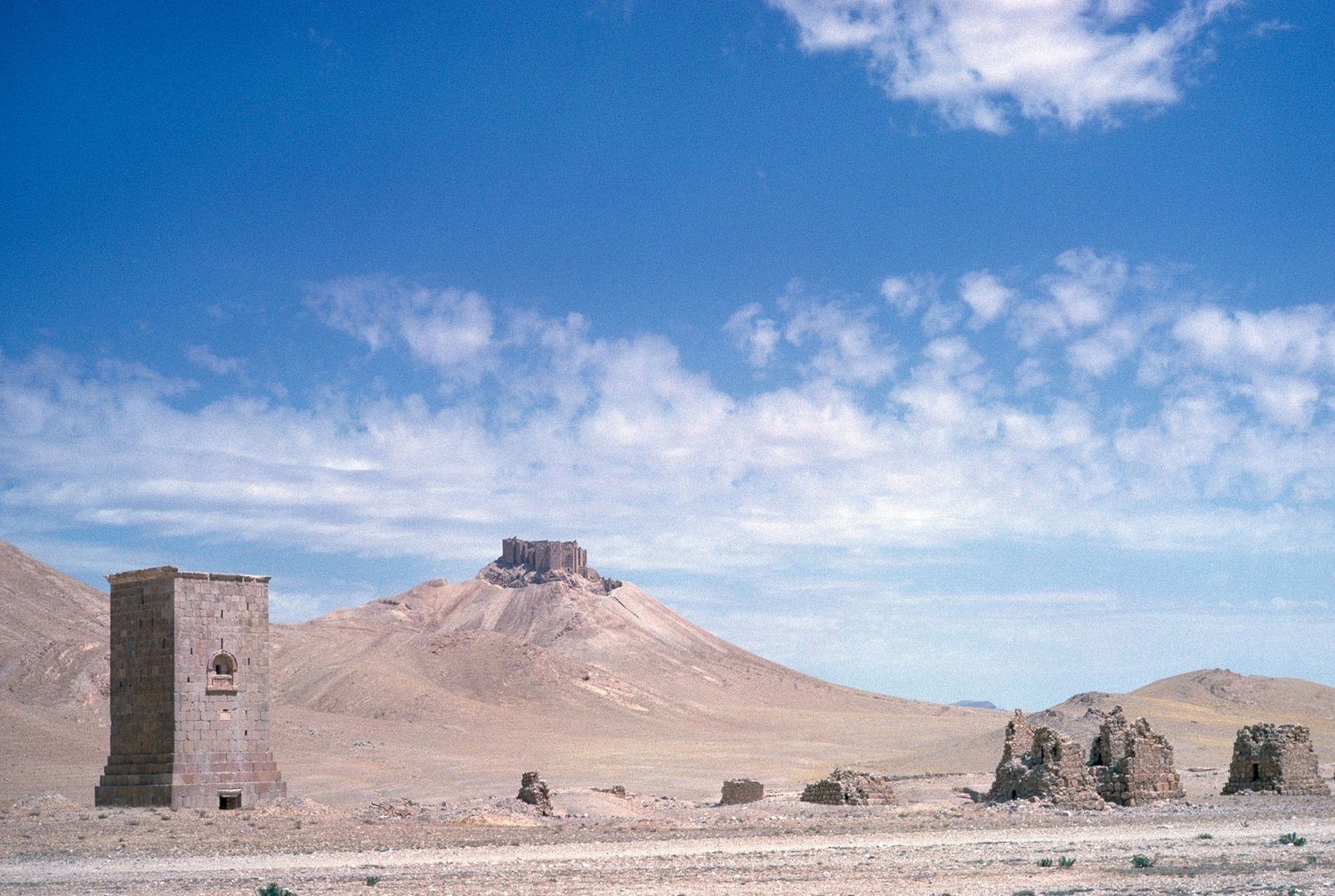 Tower tombs in the Valley of the Tombs, with the Qala in the distance. The Elahbel tomb at left was reported destroyed in August 2015.