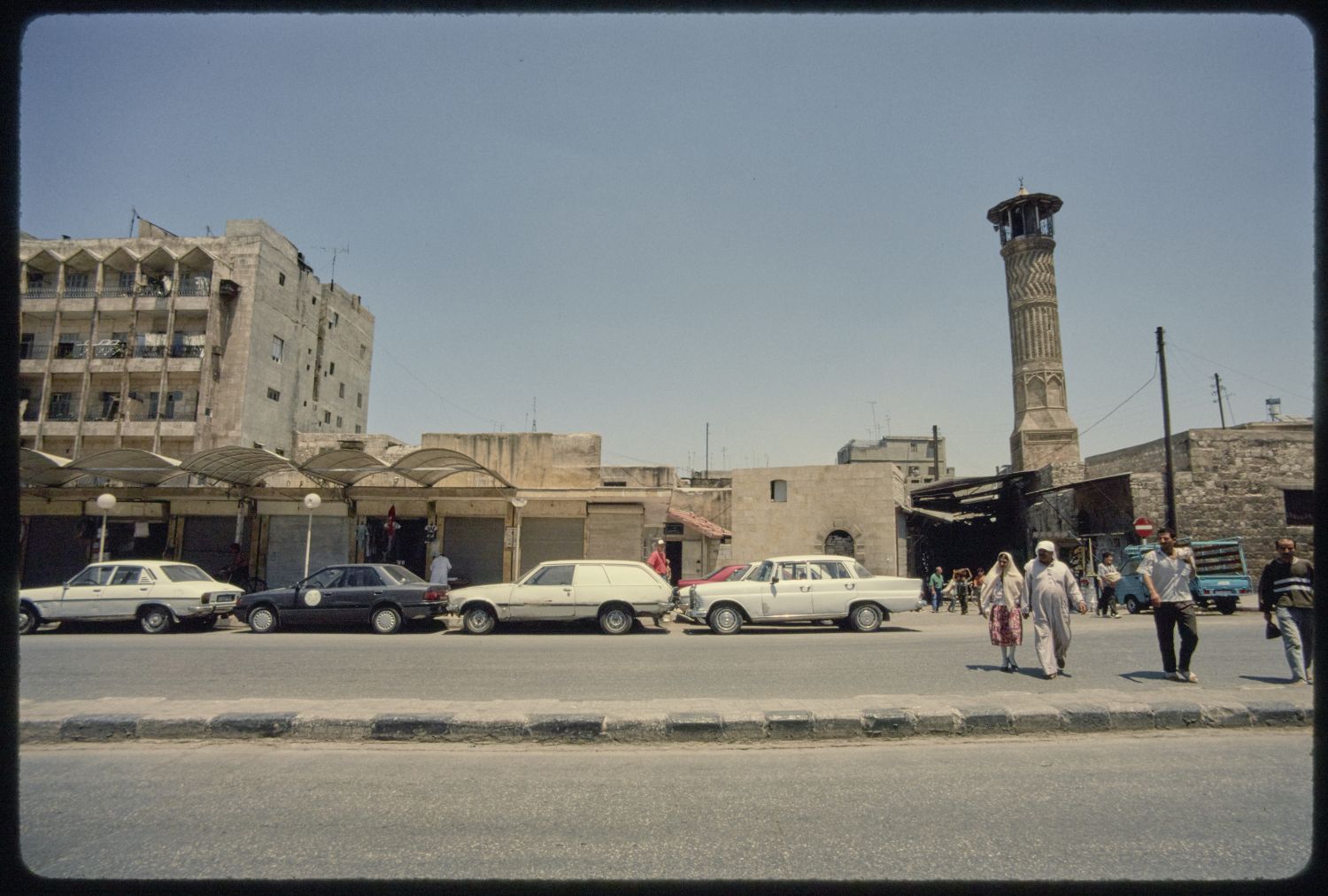 Facades along al-Mutanabbi Street, with the minaret of Jami' al-Mihmandar&nbsp;at right.