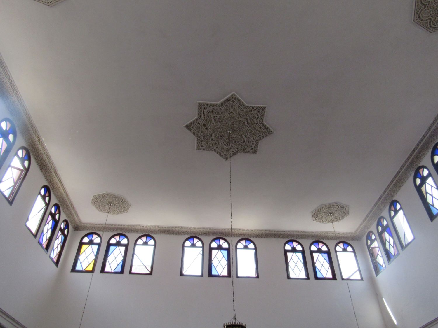 Interior view, prayer hall ceiling, chandelier suspended from eight-point star base.