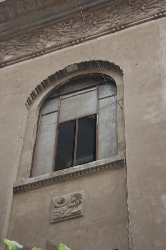 Window detail, stucco decoration with bunch of grapes surrounding the horn of plenty