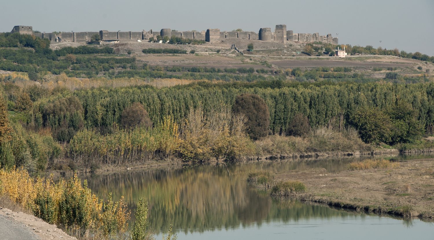 Diyarbakır Kalesi ve Surları - View of city walls on east side from the River Tigris at the bridge known as Ongözlü Köprü. The riverfront gardens known as&nbsp;Hevsel Bahçeleri are visible in the foreground.&nbsp;