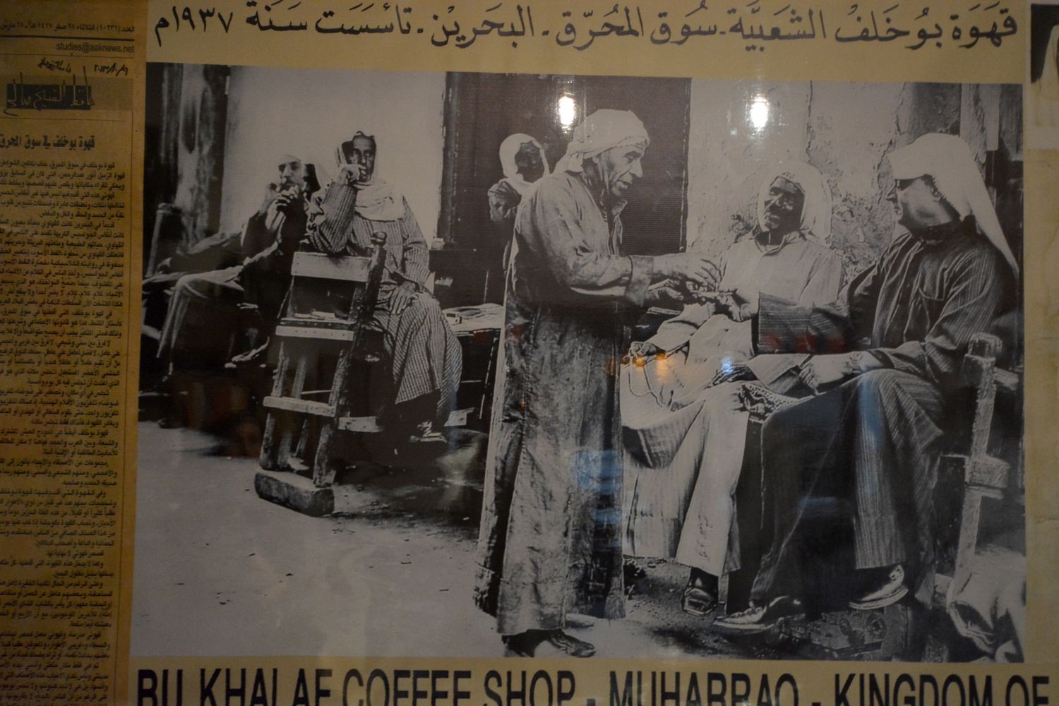 Detail of the signage in the Bu Khalaf Caf‚, wih a historic photo and text in English and Arabic.