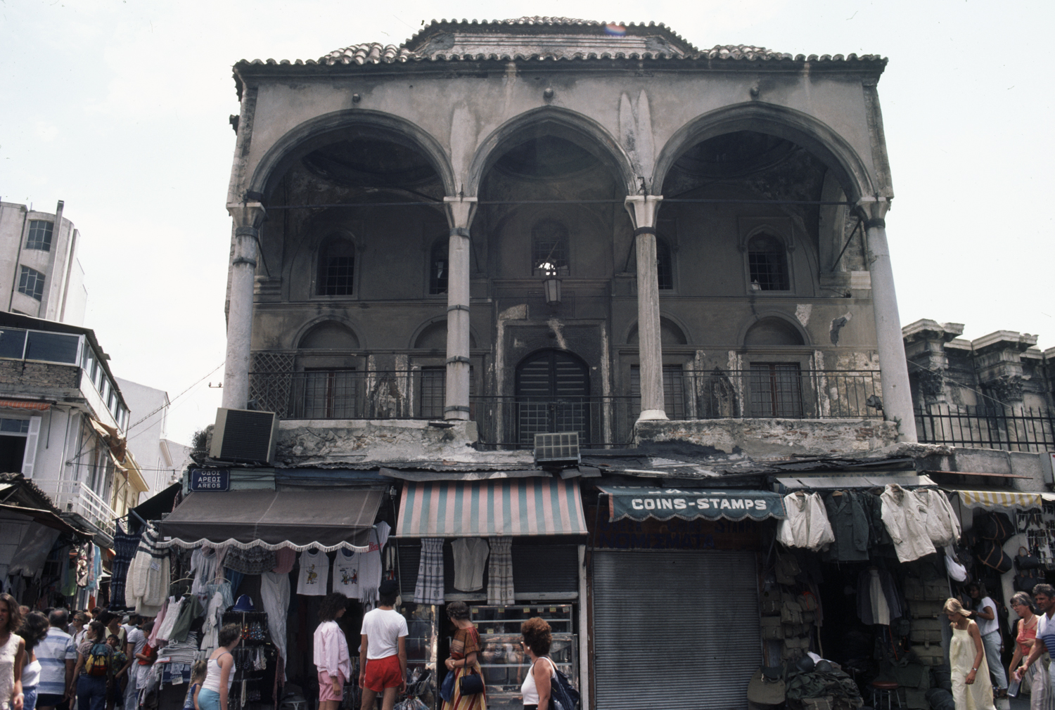 View from street level of front of mosque, with portico above shops at street level