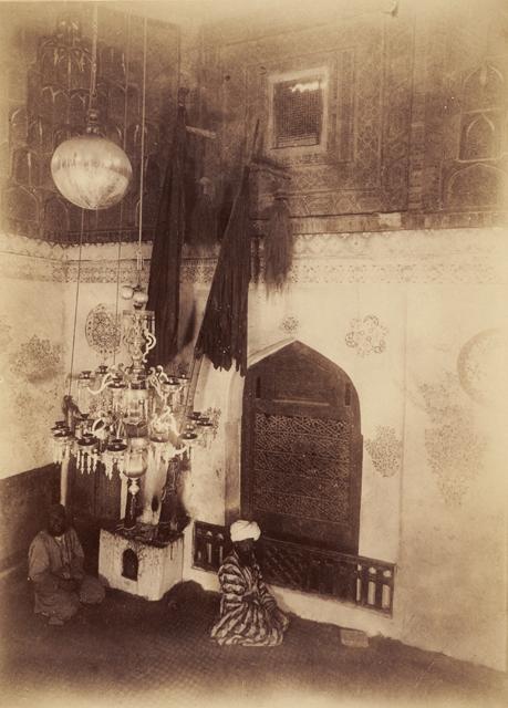 Interior view of ziyaratkhana ("pilgrimage room"). The gurkhana (the funerary chamber of Qusam ibn Abbas) is visible through the arched wooden opening and is accessible through the wooden door at the corner