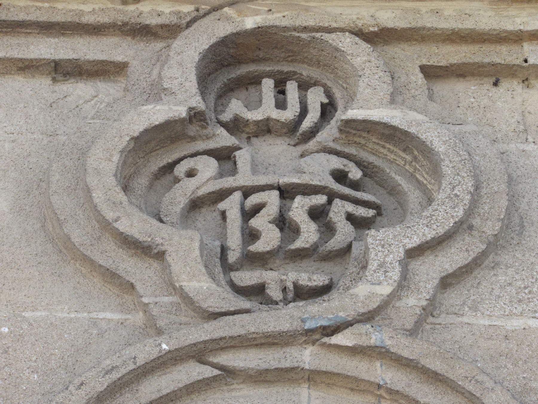 Exterior view of Masjid Mohamedi with entrance stone carving.