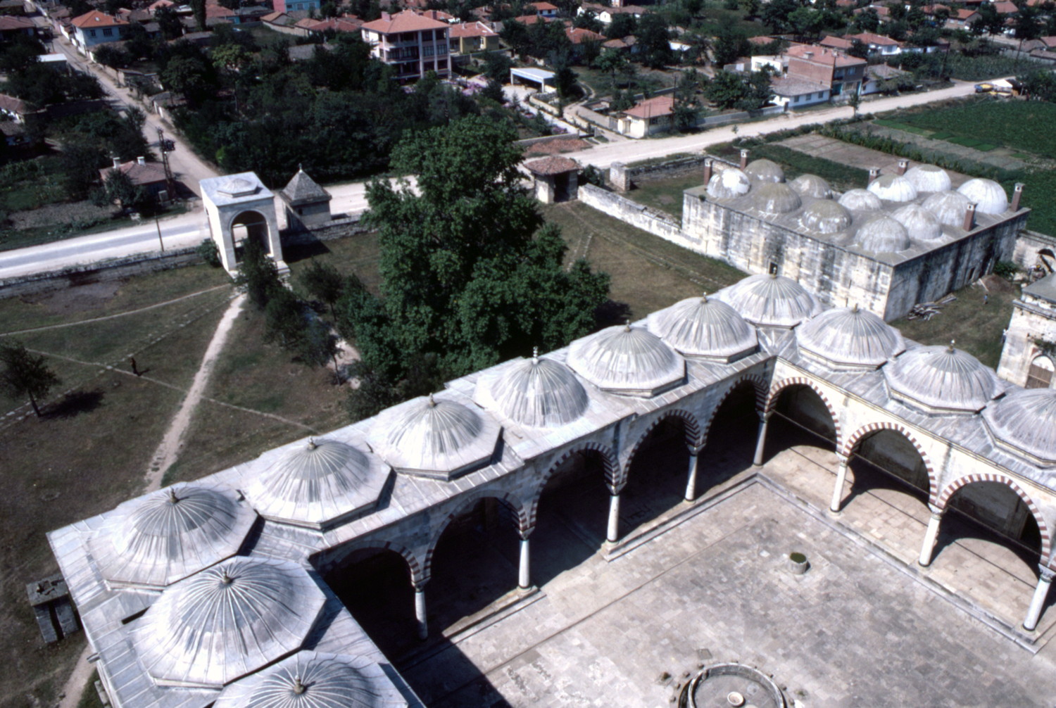 Mosque: view over the northwestern side of the forecourt and the open court and main entrance to the complex beyond.