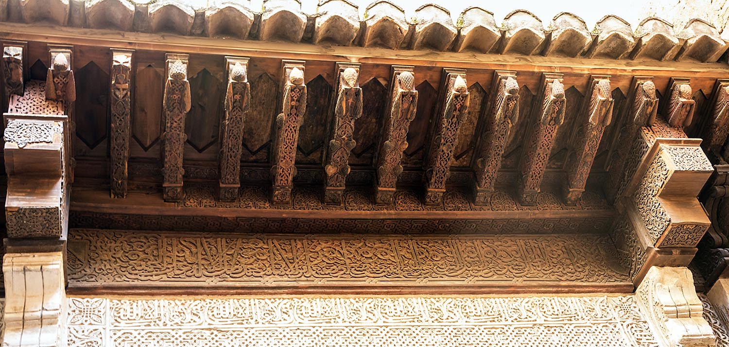 Detail view of inscriptions underneath wooden eave, Mexuar entrance