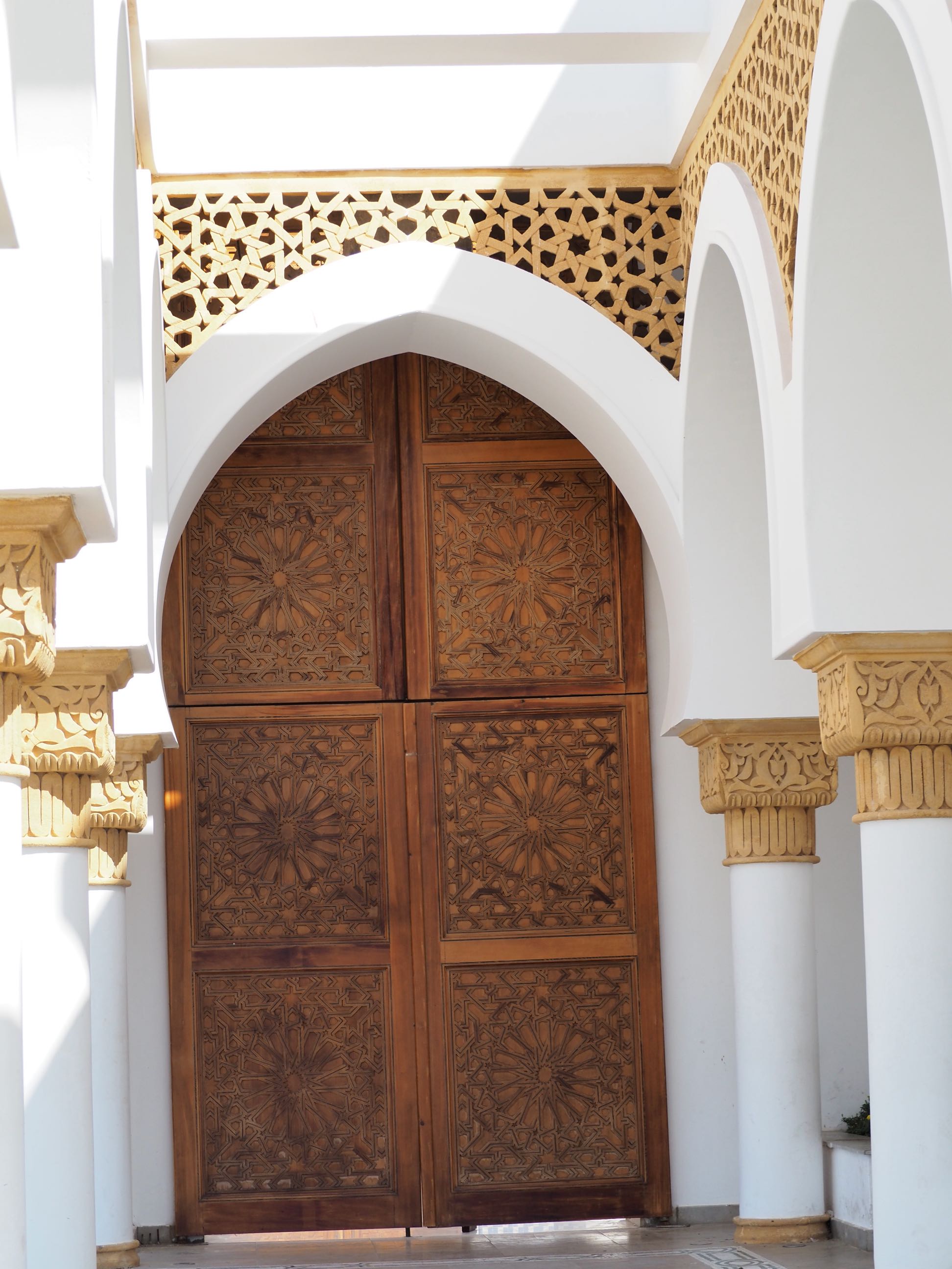 Princess Lalla ‘Abla’s Mosque  - <p>View past arches to the wood door with geometric patterns</p>
