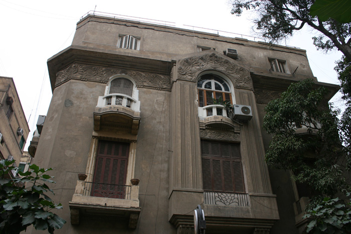 Main facade with stucco decoration under the cornice and the mitre arch