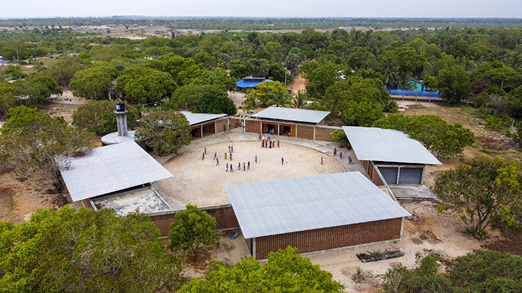 <p>Aerial view of the Lanka Learning Centre showing its pentangular plan and integration into the landscape. The architects kept all the existing trees, which now provide shade to the complex.&nbsp;</p>