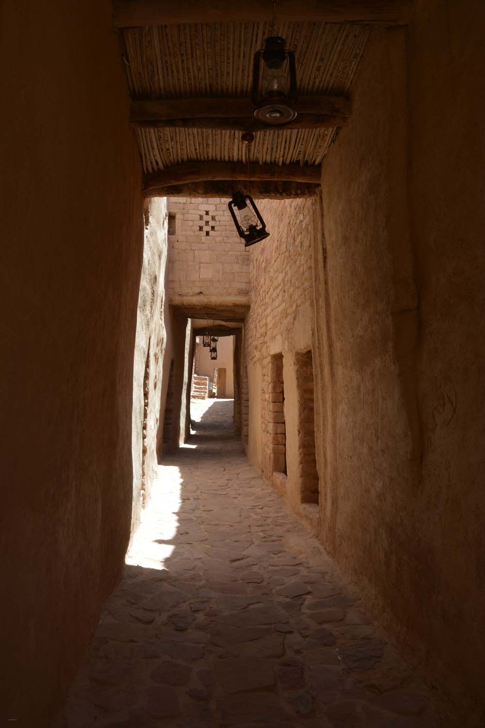al-Ula - View of a partially covered street in old town. Lanterns hanging from the ceiling.