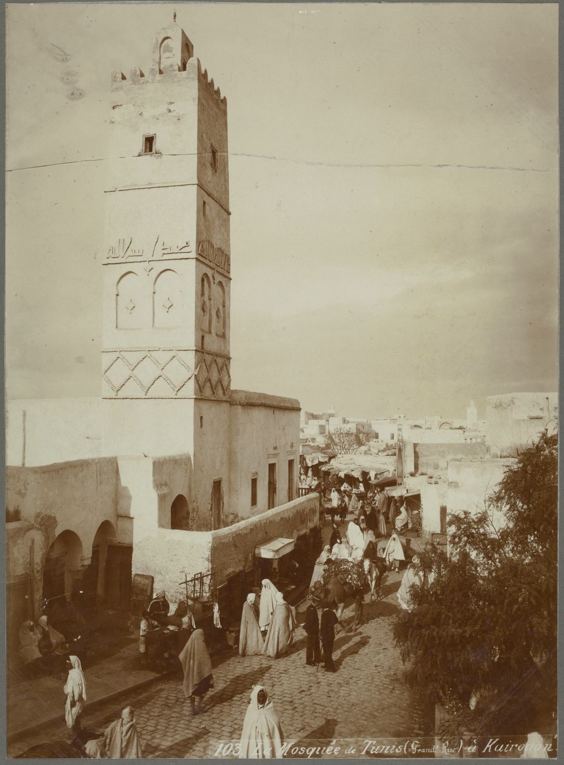 Exterior view from across a crowded street toward the minaret.