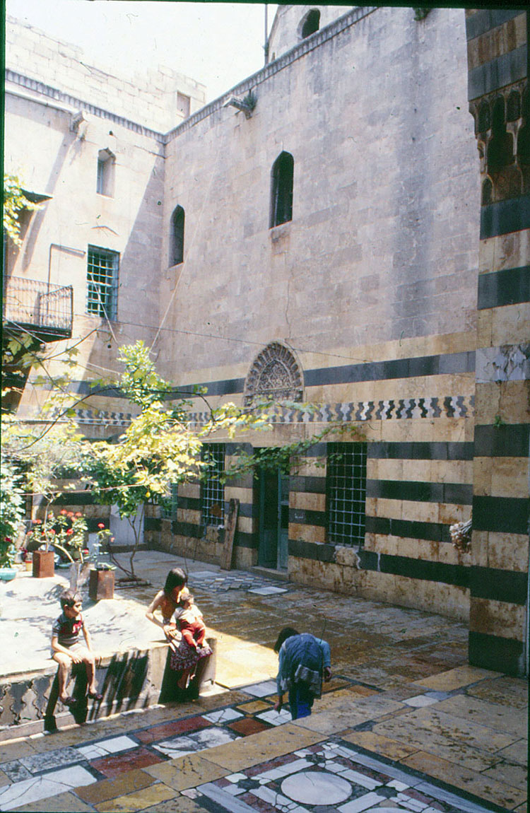 <p>View across courtyard from iwan, with decorative opus sectile floor panel visible in foreground</p>