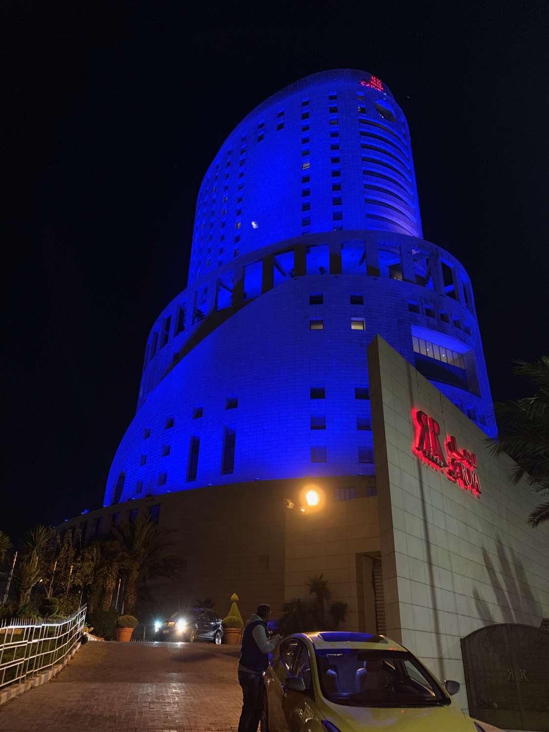 Exterior view of building at night with blue lights.