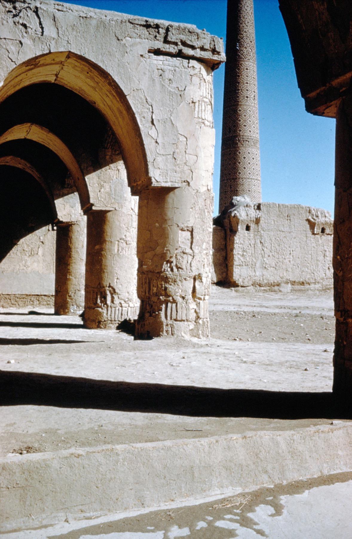 Interior view of qibla arcade with cylindrical pillars and elliptical arches, prior to restoration. The Seljuk minaret is visible in the background