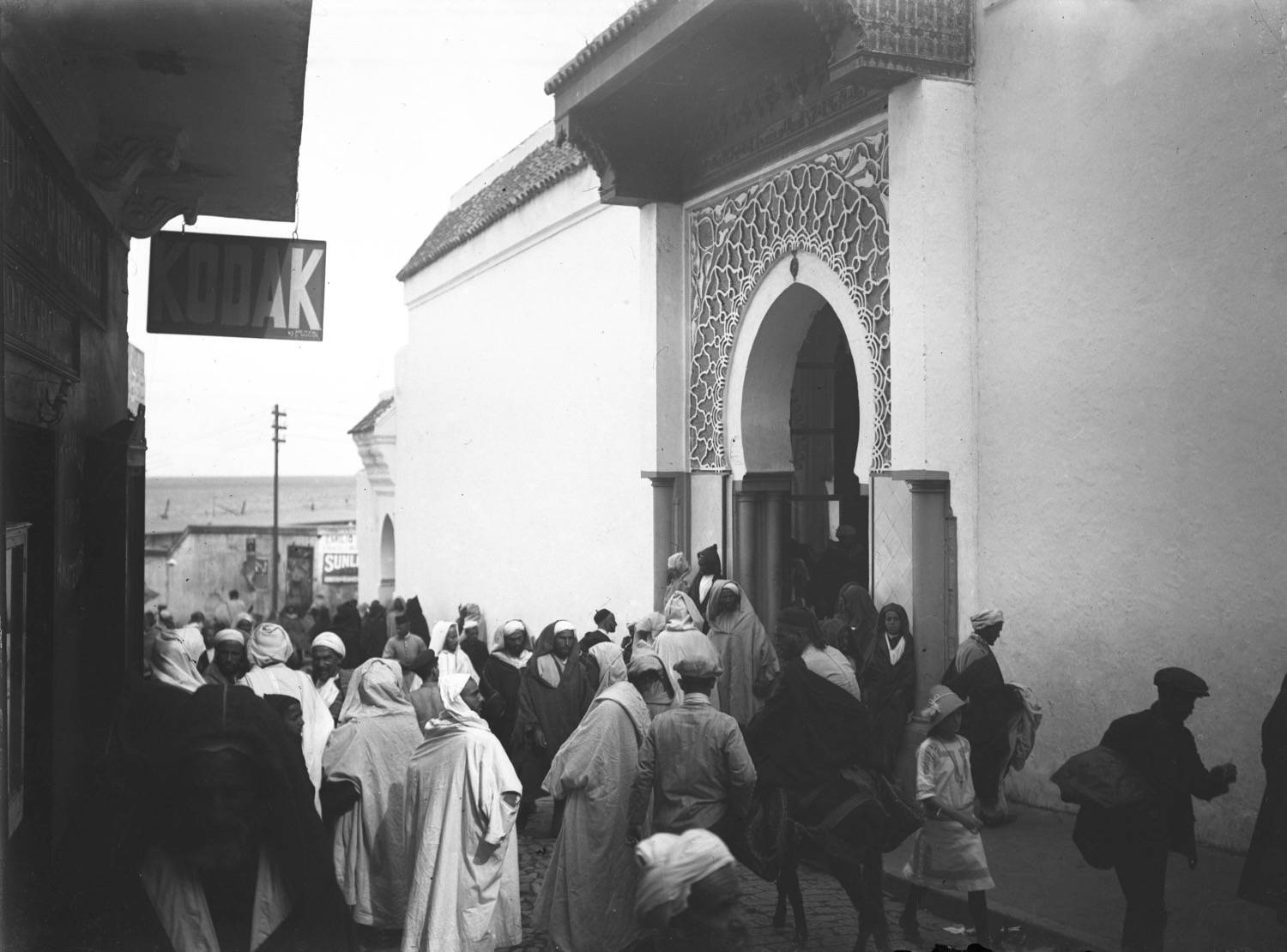 A crowd of men at the portal of the Great Mosque on Rue de la Marine