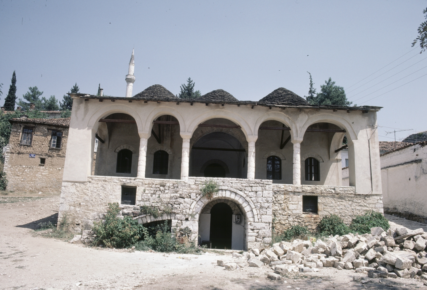 Front facade, with porch; minaret from the mosque of Aslan Pasha visible above roof