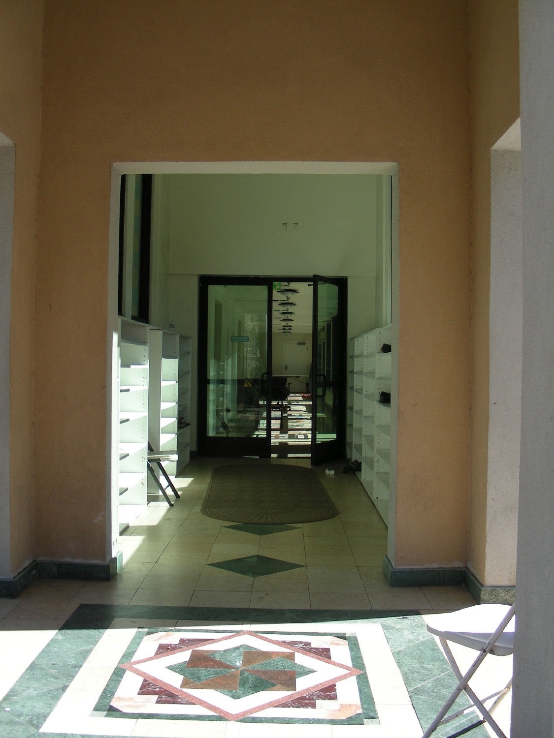 View within covered entrance portico, with shoe racks