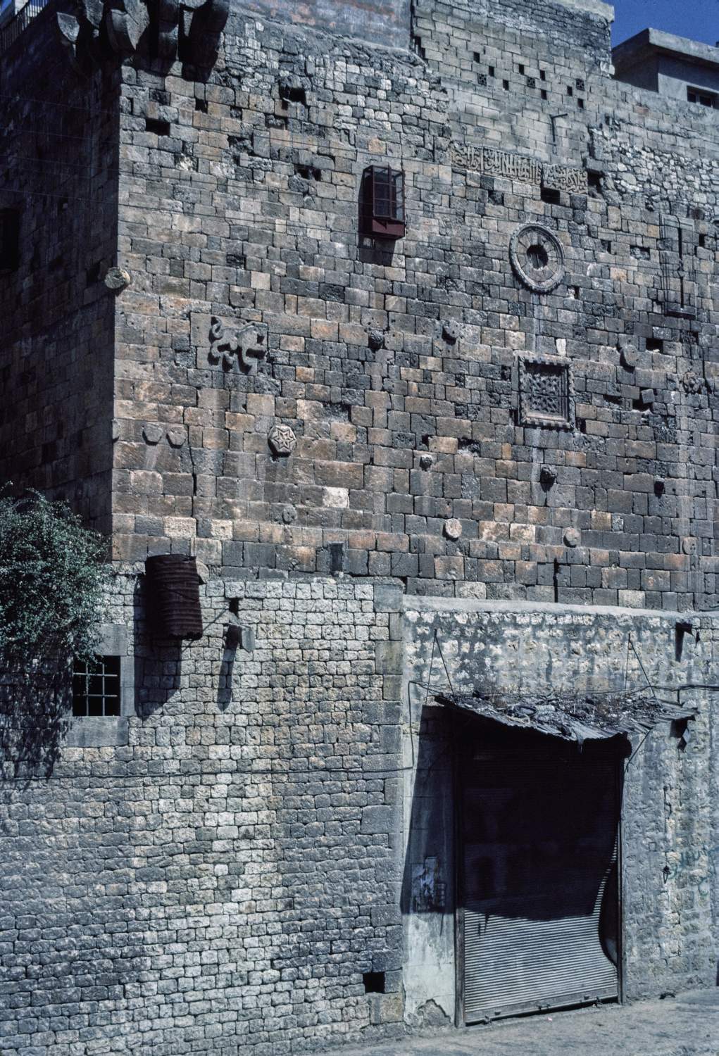Bastion on west front north of Bab Antakiyya incorporating an inscription band and carved plaques, including a rampant lion.