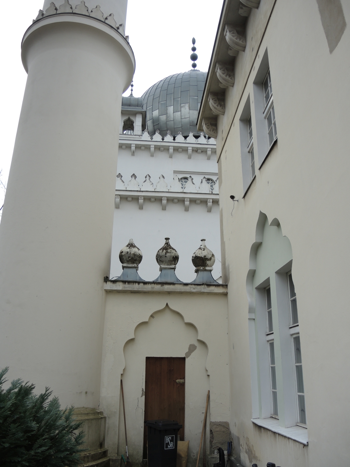 View to the base of the north minaret and a door leading to the mosque from the imam's residence, with the mosque behind