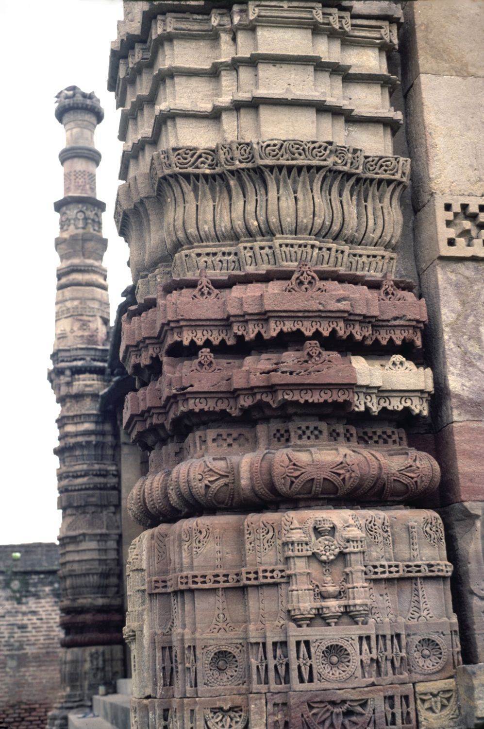 Close view of north minaret, showing carved registers including lotus medallions and a lotus-petal motif.