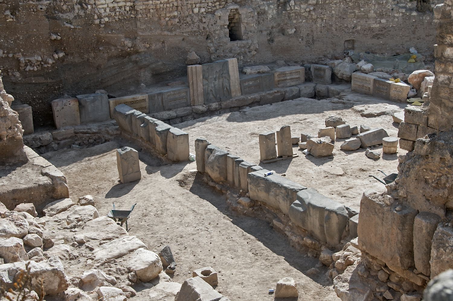 General view over excavated area facing southeast. Row of panels from platform wall constructed ca. 900 BCE visible in center.