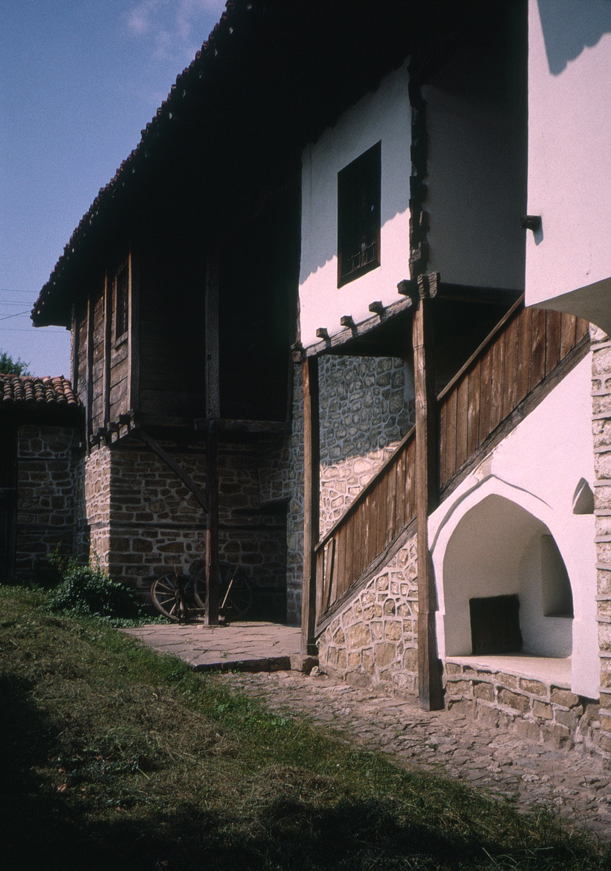 <p>This view shows the wood-framed upper level inside the courtyard; the plank enclosed volume contains the area for washing and personal hygiene. A stone wall forms a large courtyard and the ground level of the dwelling for defense. The dwelling is considered a mountain dwelling similar to those constructed during the feudal period (14th century). This rear area gives access by an open stair to a summer room above. The projecting element above the stair is part of a separate room provided for women about to give birth and during the weeks after.</p><p>(photo 2000)</p>