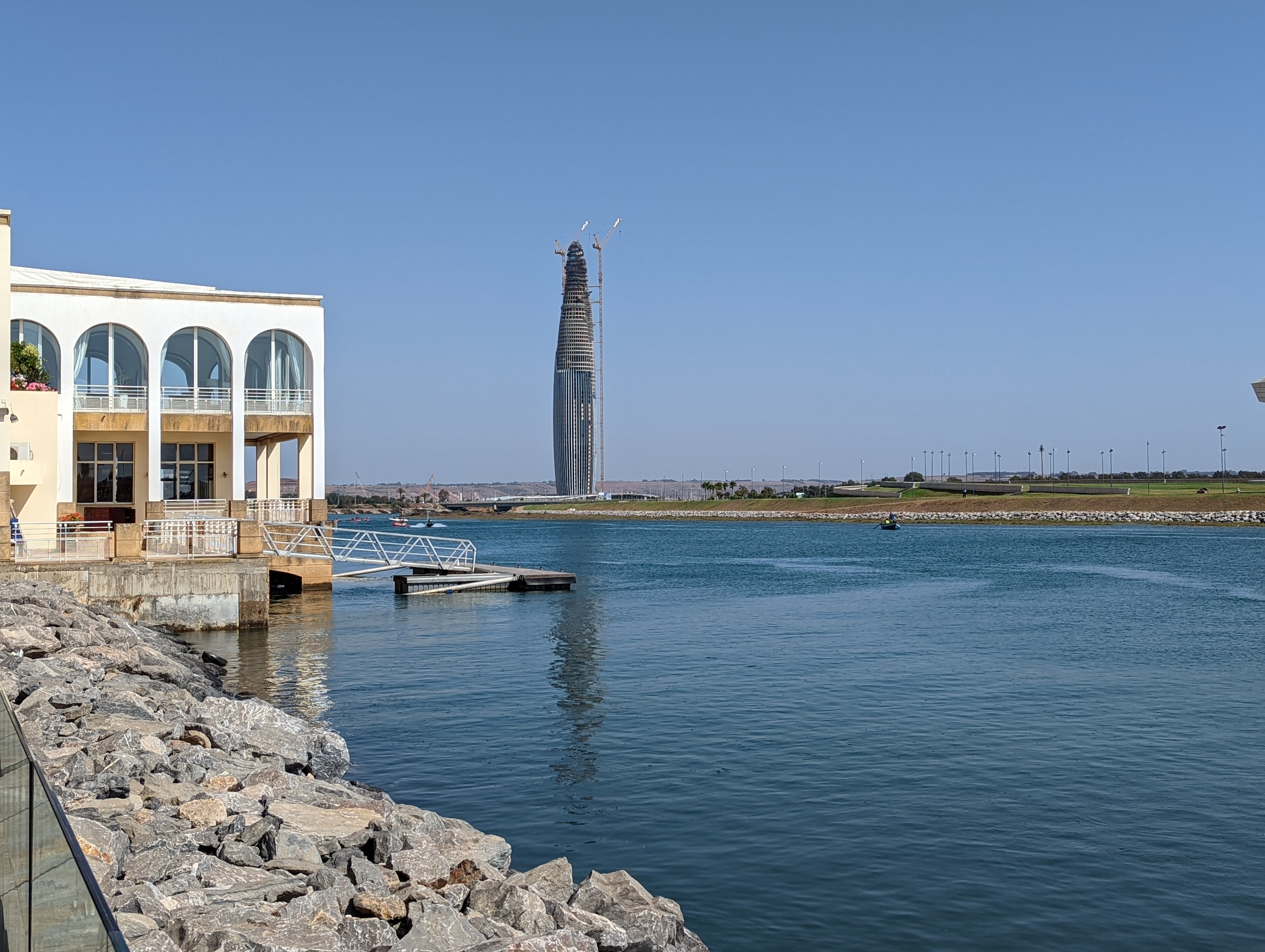 <p>View toward Mohammed VI Tower under construction past the riverbank rocks</p>