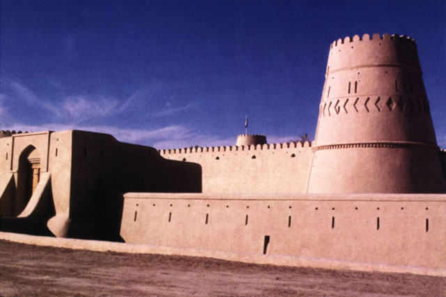 Exterior view showing restored plastering and carved decoration of walls and corner tower