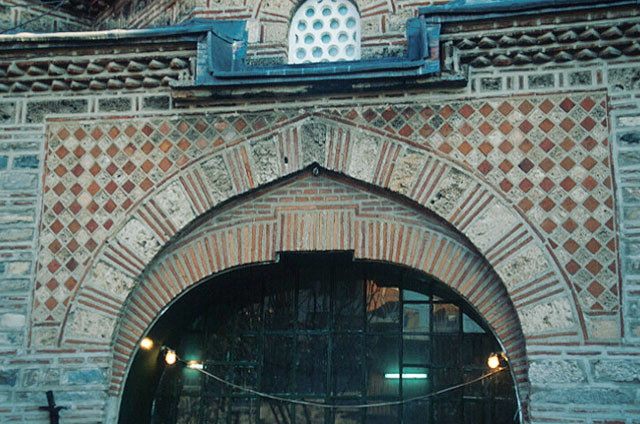 Exterior detail from upper section of entrance, showing ornamental brickwork and inner arch with raised keystone