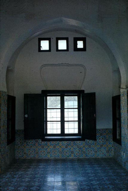 Interior view of tiled room showing clerestory windows and pointed horseshoe arch