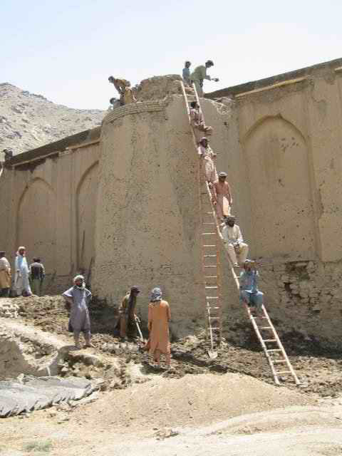 Eastern garden wall, during restoration, showing workers handing <i>pakhsa</i> to be laid on the damaged walls