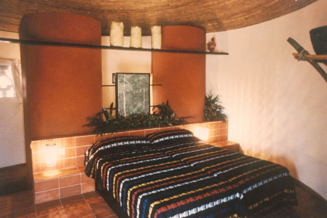 Interior view of guest room showing architectonic use of columns and braided thatch ceiling