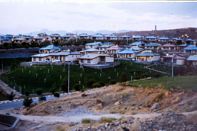 Exterior view showing modular housing units through hill-side