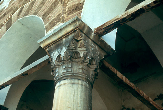 Nilüfer Hatun Imareti - Exterior detail from portico, showing muqarnas capital of marble columns and the brick and stone construction of the arches tied together with wooden beams