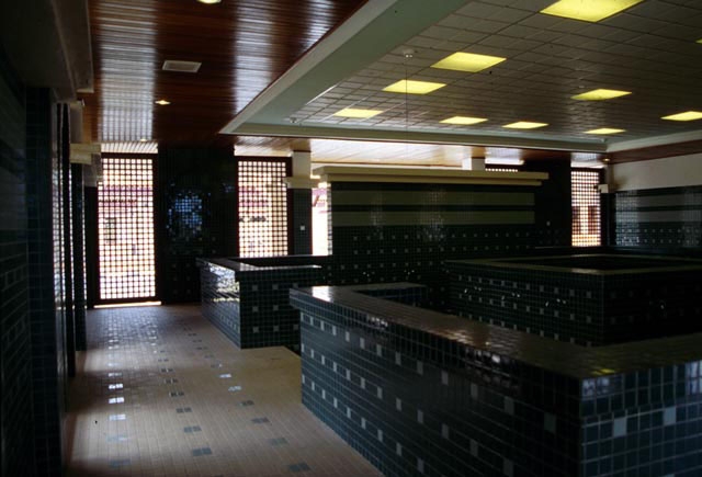 Interior view of reception, showing tile worked surfaces, mashrabiya style wondow treatments and wooden ceiling