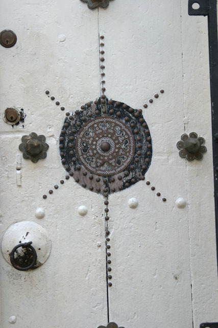 Mandhry Mosque - Exterior detail; white painted door with brass decoration