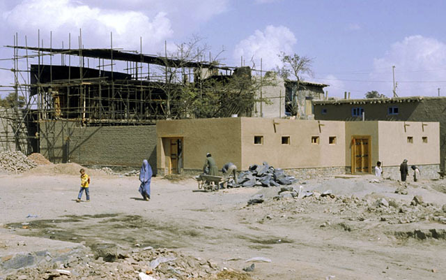 General view from southwest during restoration, with courtyard and house entrances
