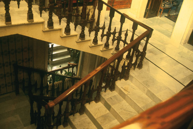 Elevated interior detail showing wood banisters and marble flooring