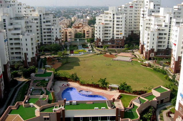 Elevated view of Udita apartment blocks and central green space, looking west. Club de Ville appears in the lower foreground while the Utsav blocks are seen in the background