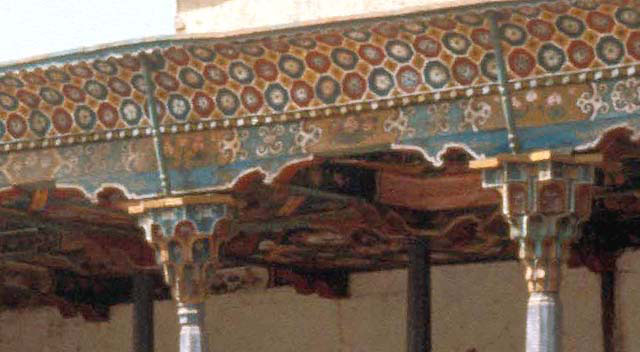 Portico detail showing muqarnas column capitals, polychrome soffit, and paneled ceiling decoration